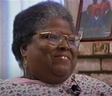 Johnnie Lacy, Independent Living Advocate, seated and smiling during an interview. Captured via video. Johnnie Lacy, Independent Living Advocate, seated and smiling during an interview. Captured via video.